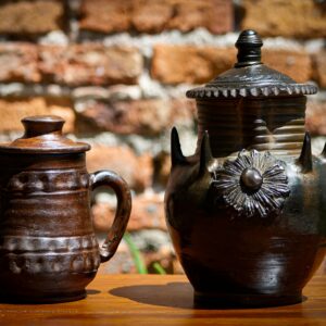 Close-up of traditional clay jars against a brick wall, showcasing rustic craftsmanship.
