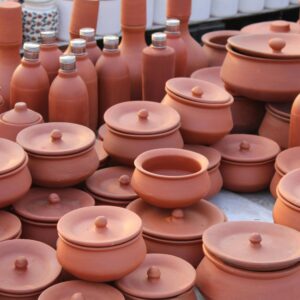 A variety of handmade clay pots and vases displayed on a market table.